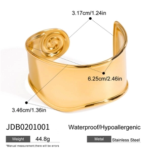 Macro view of wide 18K gold-plated stainless steel cuff bangle with swirl texture details