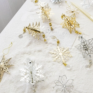 Golden and silver metal Christmas ornaments with stars and snowflakes on snow background