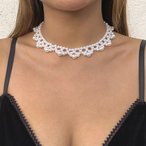 Detail of woven white pearl choker necklace featuring intricate lace-style beadwork