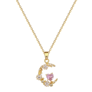 Gold moon necklace featuring a pink heart gem and star accents on white background