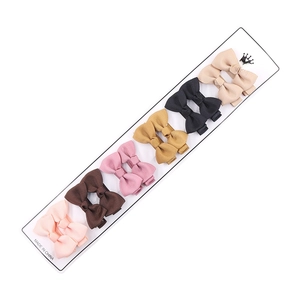 Set of six colorful grosgrain ribbon bow hair clips for kids on a white display card
