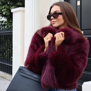 Manteau court en fausse fourrure rouge vin avec col rabattu porté par un mannequin