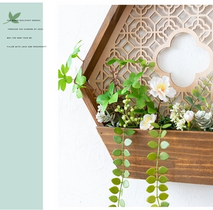 Detalle de jardinera de pared hexagonal en madera de nogal con patrones geométricos calados