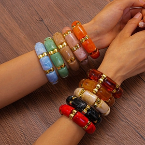 Close-up of colorful resin bamboo bracelets with marble texture and golden metal spacers