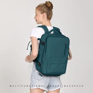 Rear view of a cyan large travel backpack on a model showing thick padded straps and buckles