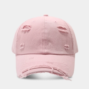 Detailed close-up showing distressed torn edges on the vintage pink cotton baseball cap