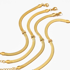 Four gold stainless steel snake chain bracelets featuring colorful small gemstone charms
