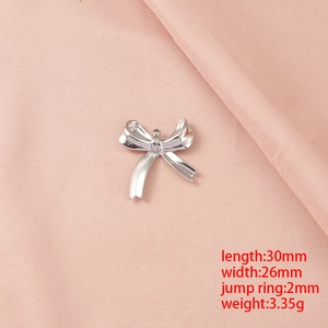 Pendentif noeud en acier argenté 30x26mm sur un fond de tissu rose et soyeux