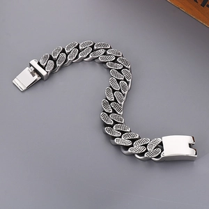 Close-up of silver punk Cuban chain bracelet with textured studs and secure clasp