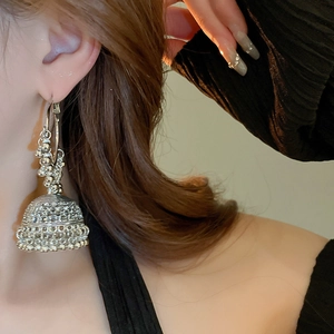 Detail of vintage silver Jhumka earrings with intricate beadwork and hollow bell design