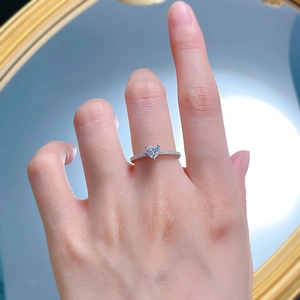 Close-up of heart-shaped diamond ring with pave setting on a woman's hand