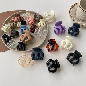 Mini matte and transparent hair claw clips set in various colors on a white surface