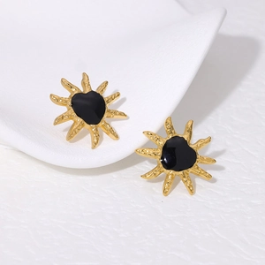 18K gold plated sunflower earrings with black heart center on white fabric
