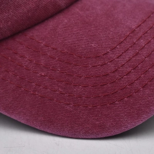 Gros plan sur la casquette bordeaux délavée avec coutures détaillées et texture velours