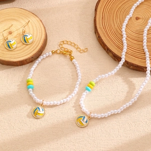 Détails d'ensemble bijoux en perles avec pendentifs de volleyball sur bois naturel
