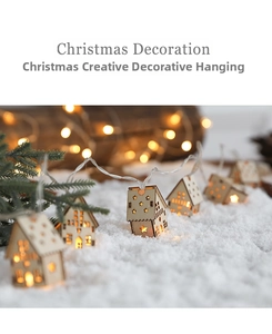 Close-up of wooden house LED string lights with hollow stars on artificial snow
