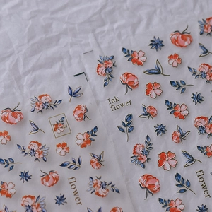 Stickers ongles 3D avec motifs de fleurs à l'encre rouge et bleue sur fond texturé
