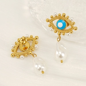 Detailed view of evil eye earrings featuring baroque pearls and gold metal textures
