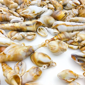 Close-up of dual-tone acrylic conch shell pendants with white loops for DIY jewelry making