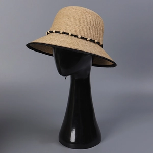 Klassischer Raffia-Sonnenhut mit Holzperlen und schwarzem Rand auf grauem Grund