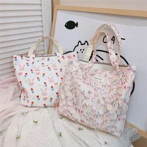 Detail of printed canvas bags with pink bunny and floral patterns and simple wish label
