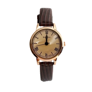 Classic women's quartz watch with gold metal case and brown leather strap on white background
