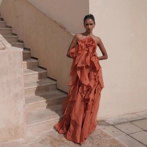 Orange halter neck tiered ruffle maxi dress featuring a large 3D flower embellishment