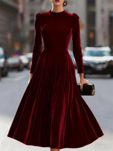 Detail of dark red velvet midi dress showing rich fabric texture and slim waistline cut