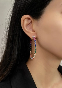 Close-up of model wearing large rainbow zircon hoop earrings with 14k gold plating