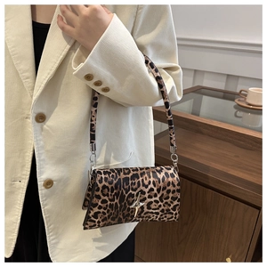 Sac à bandoulière léopard chic avec boucle étoile argentée porté par un mannequin