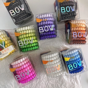 Detail of 7-piece set of colorful spiral hair ties in a transparent branded display box