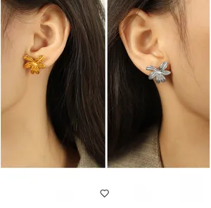 Detailed view of exaggerated 18K gold and silver plated flower earrings on model