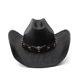 Detail of black cowboy hat with silver bull head emblem on a brown leather band