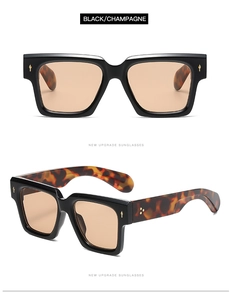 Detail of square black sunglasses with champagne lenses and gold metal studs