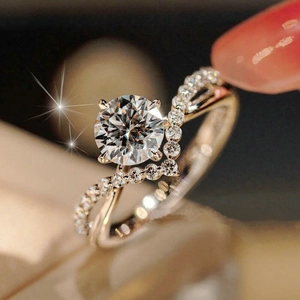 Macro shot of a four-prong crown diamond ring with V-shaped rose gold twisted band