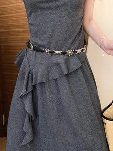 Detail of vintage silver sunburst metal pieces on a black leather waist belt