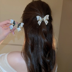 Dettaglio di un fermaglio per capelli a farfalla a doppio strato con zirconi e madreperla