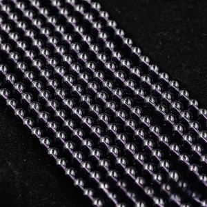Macro shot of polished purple crystal beads on a string with high clarity detail