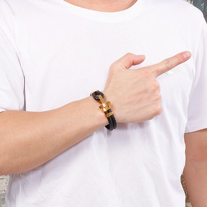 Gros plan d'un bracelet tressé pour homme avec boucle géométrique dorée sur le poignet