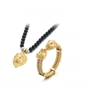 Detailed view of the 18K gold lion head pendant necklace and stainless steel cable bracelet