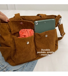 Detail view of brown corduroy tote bag showing large capacity and front utility pockets
