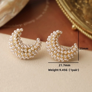 Macro shot of moon-shaped pearl earrings with 25mm height and 21.7mm width specs