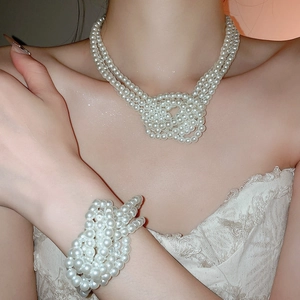 Close-up of knotted multi-layer pearl necklace and matching bracelet on model