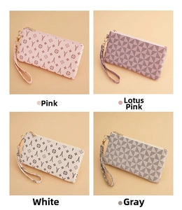 Close-up of four stylish wristlet clutch bags in pink, white and grey geometric patterns