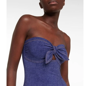 Detail of blue denim bandeau top featuring a central bow tie and yellow stitching