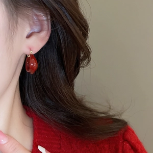 Gros plan de boucles d'oreilles émaillées rouges en forme de U en plaqué or 14K sur un mannequin