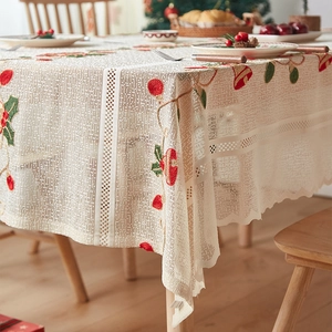 Detail of Christmas table runner with red holly embroidery and delicate lace mesh