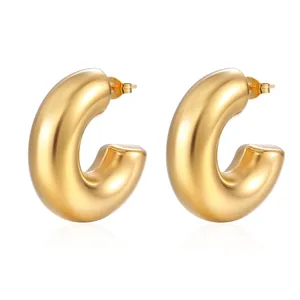 Detailed macro view of high-polished chunky gold hollow hoop earrings with a mirror finish