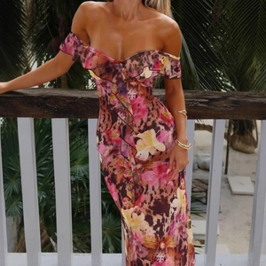 Detail of floral and leopard print summer dress with ruffled off-shoulder neckline