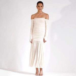 Détail de l'ourlet plissé élégant et du tissu extensible doux de la robe beige à épaules nues